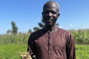 Nigerian farmer displaying crop.