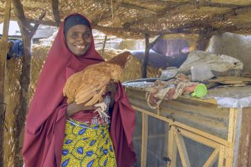 Nigerian woman holding a chicken
