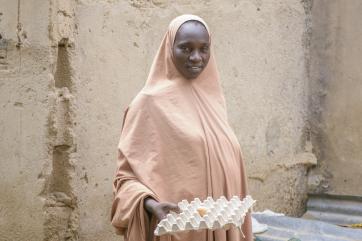 A person holding a tray of chicken eggs.