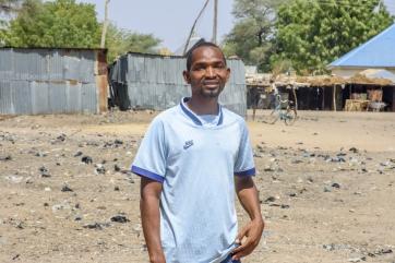 A person standing at a decommissioned dumpsite.