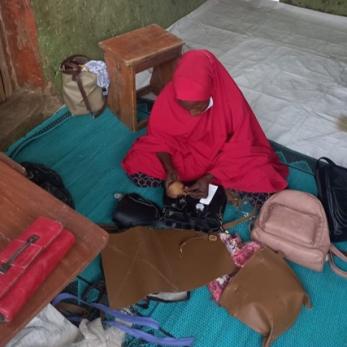 A person making handbags.