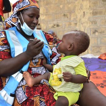 A person feeding a baby.