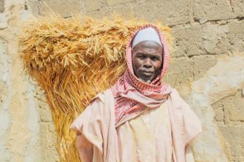 A man stands in front of wall and looks at the camera in nigeria.