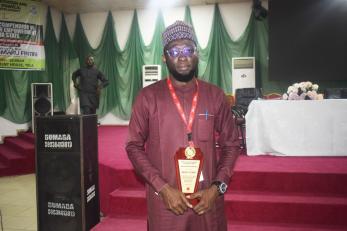  a mercy corps nigeria team member posing with the award from adamawa state government.