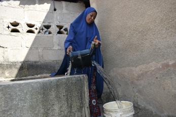 Na’ima demonstrates how she drew water from the well before the intervention.
