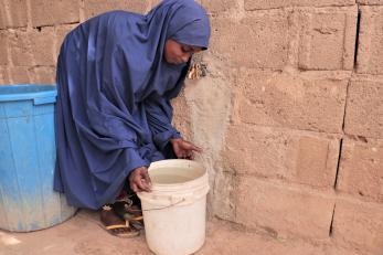 A person picking up a bucket.