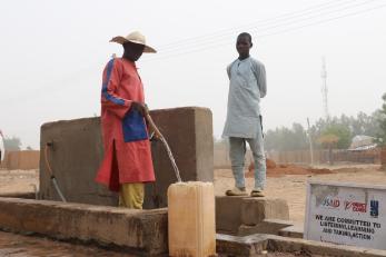 A person filling a jerry can with water.