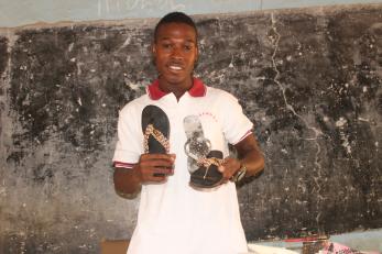A person displays slippers they designed after participating in the livelihood training program.