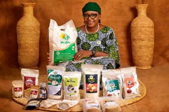 A business entrepreneur proudly displaying the wide range of packaged products produced by their company.