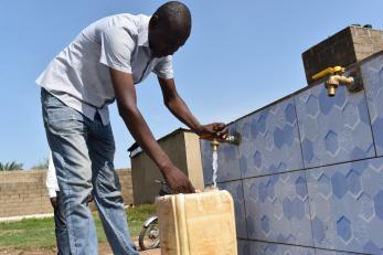 A person filling a jerry can with water.