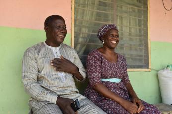 A husband and wife sitting together and smiling.