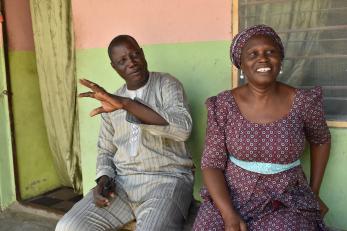 A husband and wife sitting together and smiling.