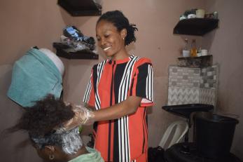 A person performing a hair treatment while training in salon work.