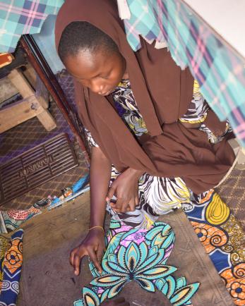 A person decorating a gown.