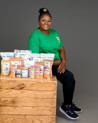 A person sitting next to packaged products from their company.