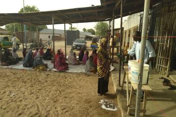 Participants practice social distancing as they sit and wait to receive their food items.