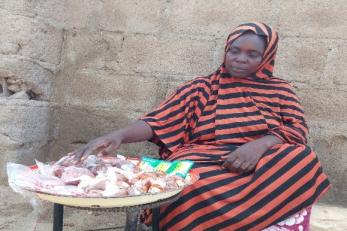 A participant sits at a table with a large plate filled with raw meat cuts.