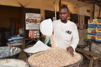 A person pouring dry goods into a bowl. 