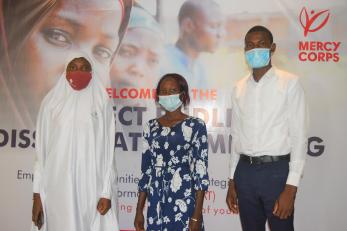 Three young people posing together at an event.