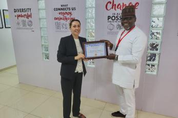 Ndubisi Anyanwu, Country Director Nigeria and Margarita Aswani, Chief of Party, RRA pose with Certificate of Recognition from Adamawa state.