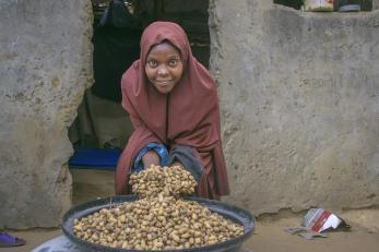 A farmer displaying groundnuts they harvested from their farm. 