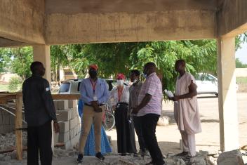 Mercy Corps Nigeria country director, director of programs, and Bama field manager supervise ongoing construction work at the skills acquisition center.