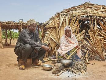 Man and woman cooking outside of their home