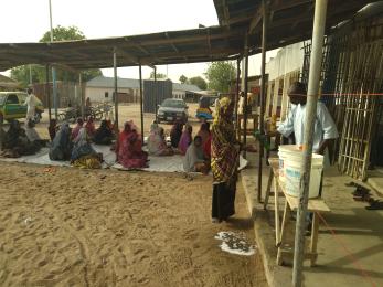 Participants practice social distancing as they sit and wait to receive their food items.