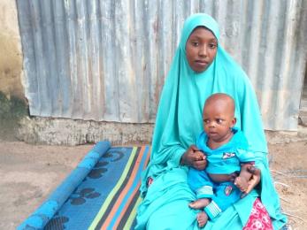 A participant sits while holding and infant.