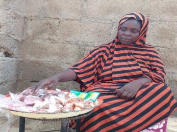A participant sits at a table with a large plate filled with raw meat cuts.