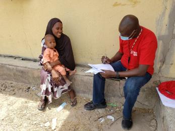 A mercy corps representative completing paperwork with a participant.  