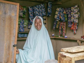 Amina inuwa happily posed for a picture inside her provision store.