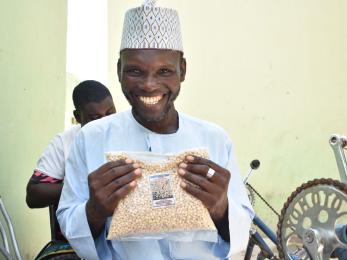 A person displaying a pack of cowpea processed by the Gamayya Disabled Group.