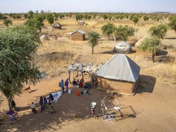 An aerial view of farmer and herder community members gathering.