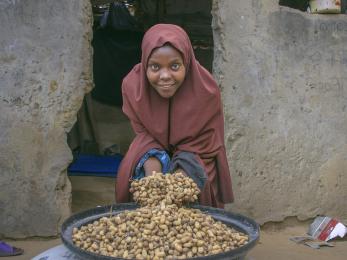 A farmer displaying groundnuts they harvested from their farm. 